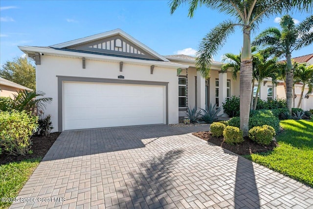 ranch-style home with a garage, decorative driveway, and stucco siding