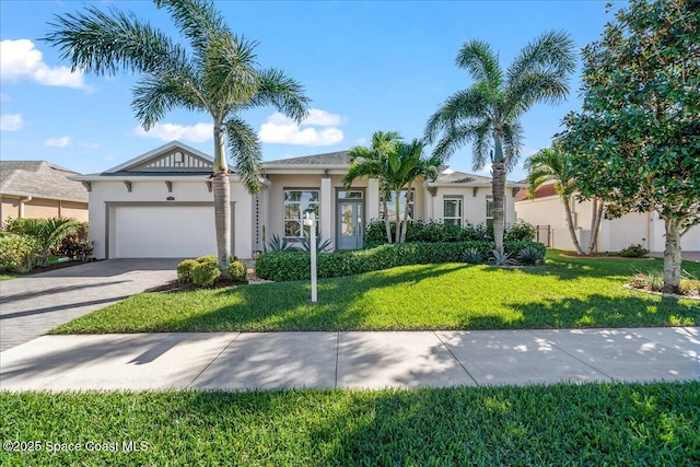 single story home featuring a garage, a front lawn, decorative driveway, and stucco siding