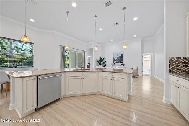 kitchen with stainless steel dishwasher, a sink, visible vents, and tasteful backsplash