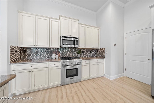 kitchen featuring light wood finished floors, tasteful backsplash, ornamental molding, and stainless steel appliances