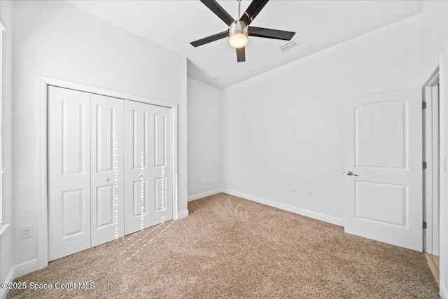 unfurnished bedroom with carpet, a closet, visible vents, ceiling fan, and baseboards