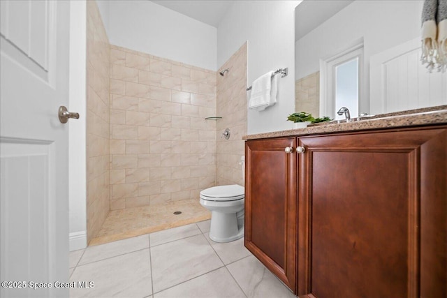 full bath with vanity, tile patterned flooring, a tile shower, and toilet