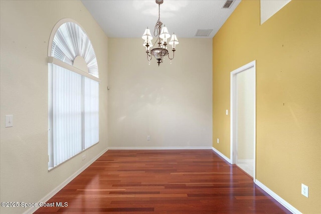 unfurnished room featuring visible vents, dark wood finished floors, and a wealth of natural light