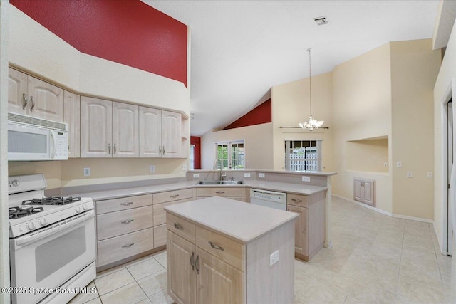 kitchen featuring light brown cabinets, white appliances, a kitchen island, a sink, and light countertops