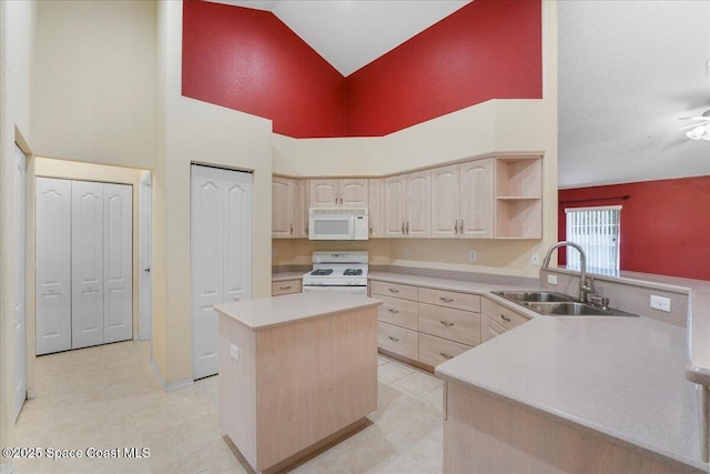 kitchen featuring white appliances, light countertops, a sink, and light brown cabinetry