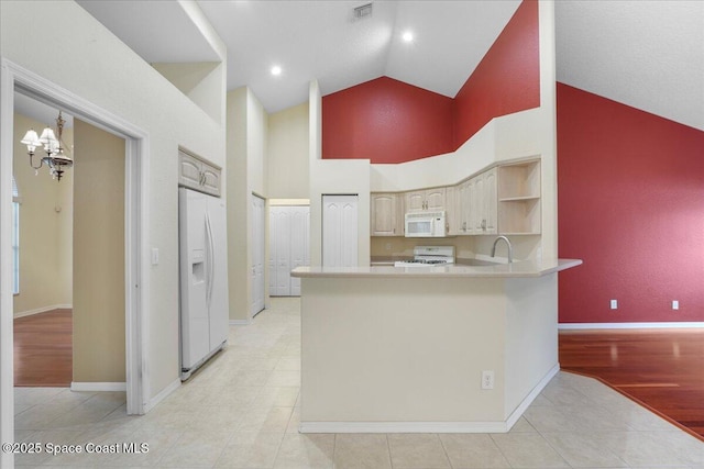 kitchen with white appliances, visible vents, a peninsula, an inviting chandelier, and light countertops