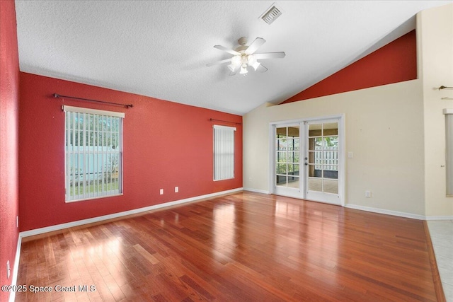 unfurnished room with lofted ceiling, visible vents, wood finished floors, and a ceiling fan