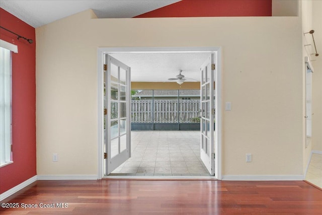 empty room with a ceiling fan, baseboards, wood finished floors, and french doors