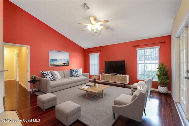 living area with dark wood-style floors, lofted ceiling, visible vents, and a ceiling fan