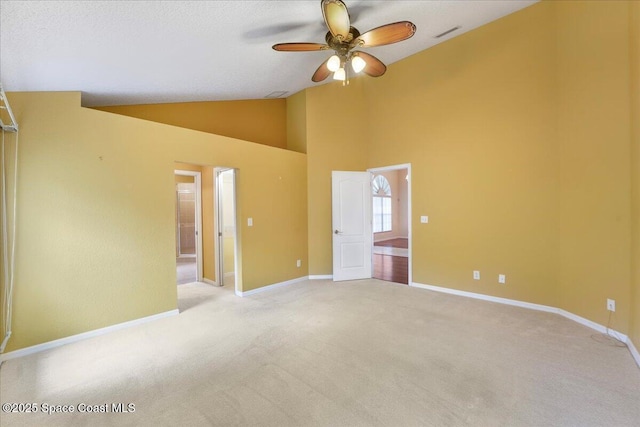 empty room with visible vents, baseboards, a ceiling fan, light colored carpet, and high vaulted ceiling