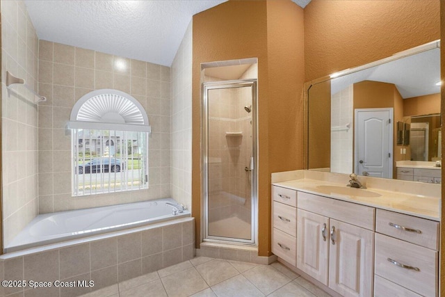 bathroom featuring a garden tub, a shower stall, tile patterned flooring, and vanity