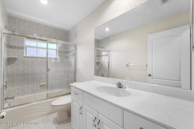 full bathroom featuring tile patterned flooring, vanity, toilet, and bath / shower combo with glass door