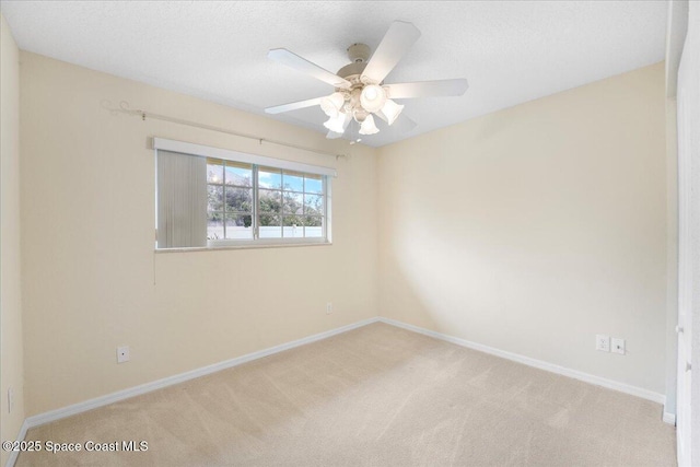 empty room with a ceiling fan, light carpet, a textured ceiling, and baseboards