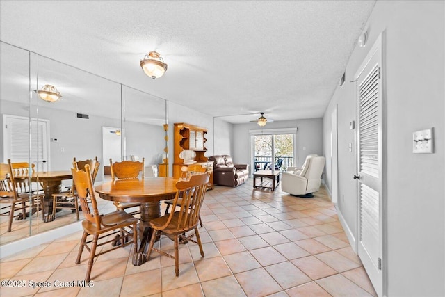 dining area featuring a ceiling fan, visible vents, a textured ceiling, and light tile patterned floors