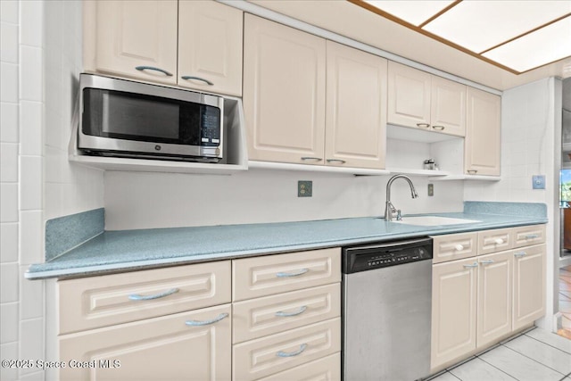 kitchen featuring stainless steel appliances, light tile patterned floors, a sink, and open shelves