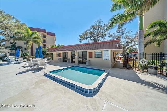 pool with a patio and fence