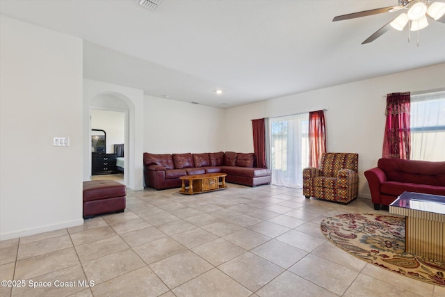 living area with light tile patterned floors, baseboards, arched walkways, a ceiling fan, and recessed lighting