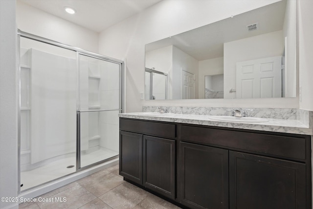 full bath with double vanity, a stall shower, visible vents, and a sink