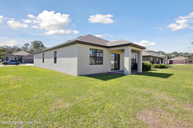 back of property featuring a shingled roof, a residential view, a lawn, and stucco siding