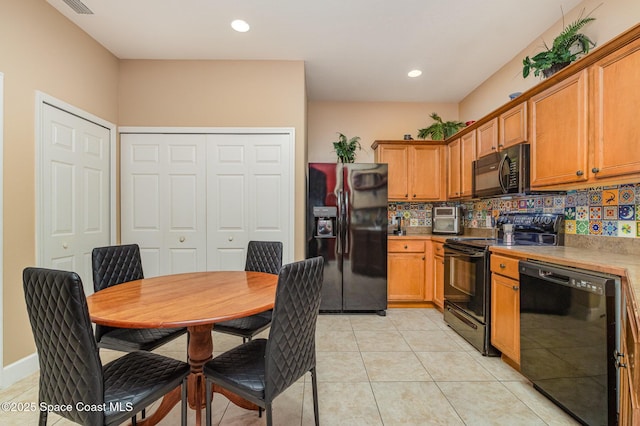 kitchen with light tile patterned floors, black appliances, light countertops, brown cabinets, and backsplash