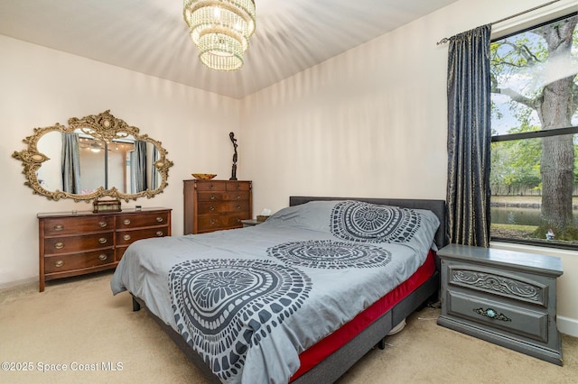 carpeted bedroom with an inviting chandelier