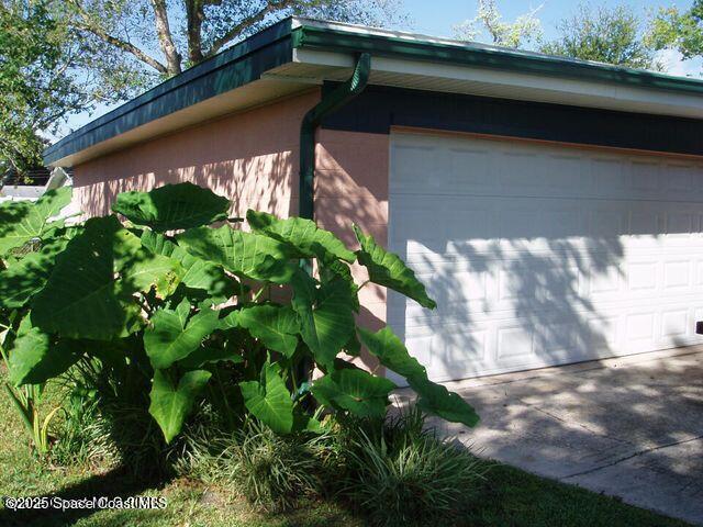 view of side of property with concrete driveway and stucco siding