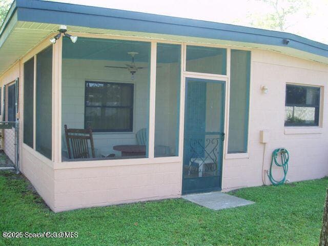 exterior space featuring a yard and a sunroom