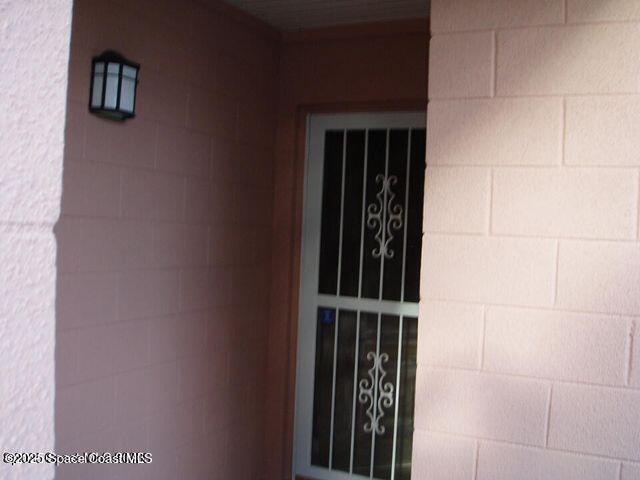 doorway to property featuring concrete block siding