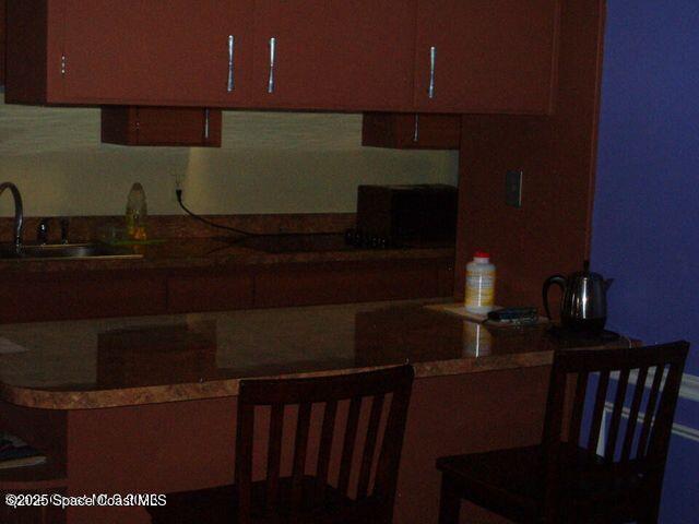 kitchen featuring dark countertops and a sink