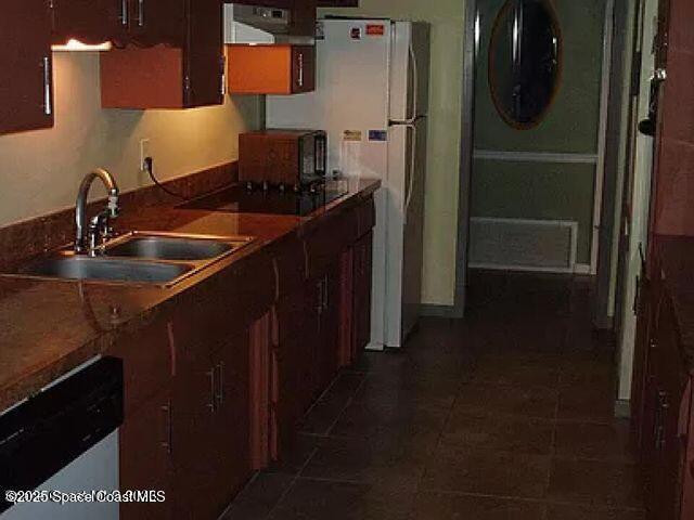 kitchen with dishwasher, dark countertops, washer / clothes dryer, black electric stovetop, and a sink