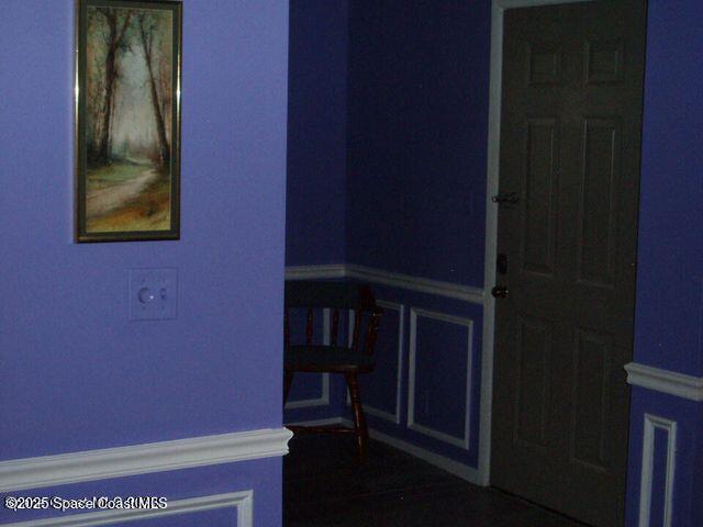 interior space with wainscoting and a decorative wall