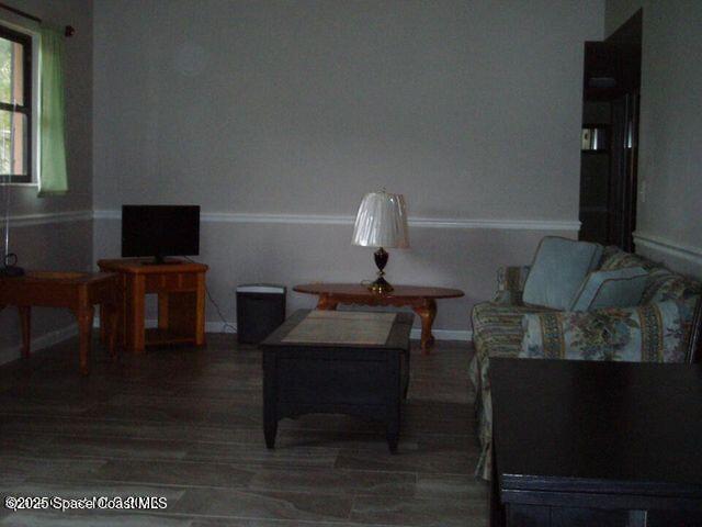 living room featuring dark wood finished floors and baseboards