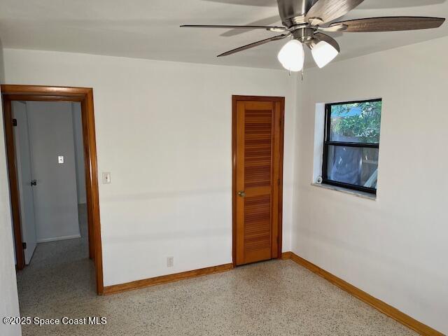 124 E Dover St E, Satellite Beach, FL 32937 - spare room with baseboards, dark aggregate flooring, and ceiling fan