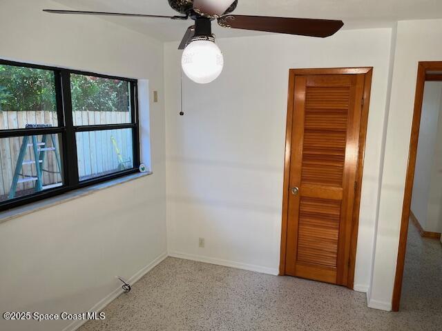 124 E Dover St E, Satellite Beach, FL 32937 - unfurnished room with ceiling fan, baseboards, and speckled floor