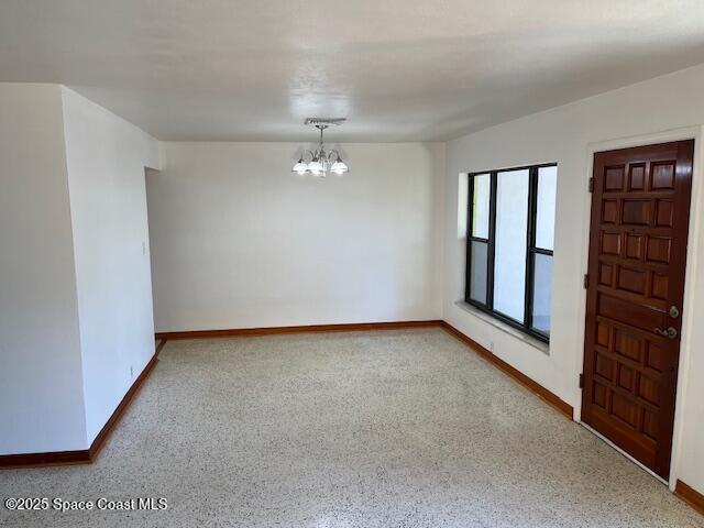 124 E Dover St E, Satellite Beach, FL 32937 - spare room with a chandelier and baseboards