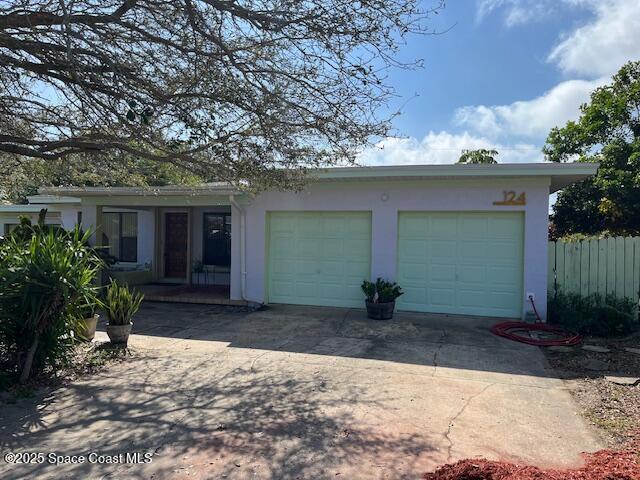 124 E Dover St E, Satellite Beach, FL 32937 - view of front of home featuring concrete driveway, stucco siding, and a garage