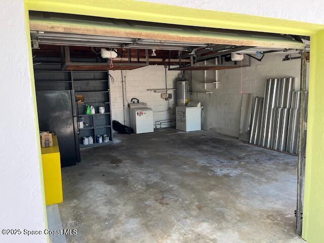 124 E Dover St E, Satellite Beach, FL 32937 - garage with gas water heater, washer / clothes dryer, and freestanding refrigerator