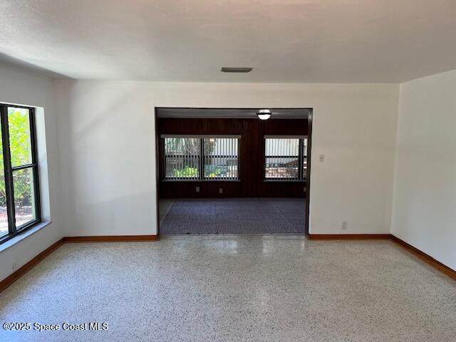 124 E Dover St E, Satellite Beach, FL 32937 - empty room featuring baseboards and speckle patterned floor