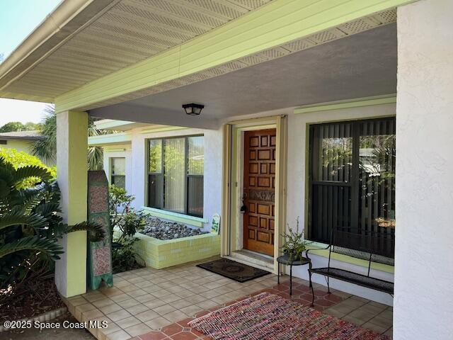 124 E Dover St E, Satellite Beach, FL 32937 - view of exterior entry featuring covered porch and stucco siding