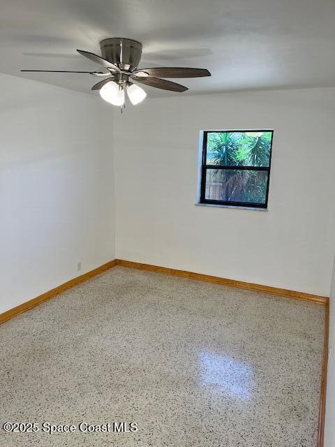 124 E Dover St E, Satellite Beach, FL 32937 - empty room with speckled floor, baseboards, and ceiling fan