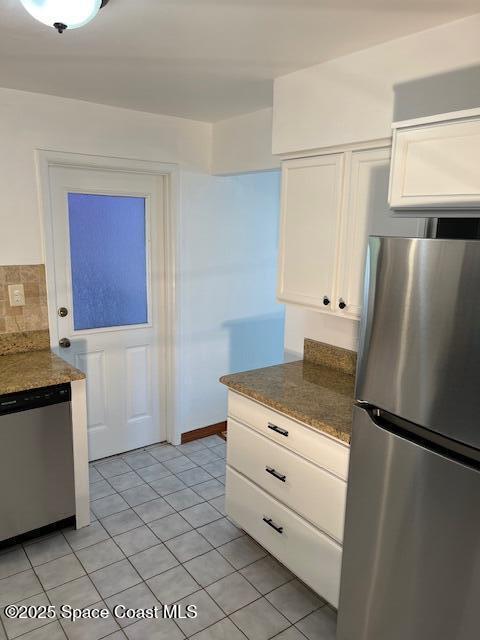 124 E Dover St E, Satellite Beach, FL 32937 - kitchen featuring appliances with stainless steel finishes, white cabinets, light tile patterned floors, and backsplash