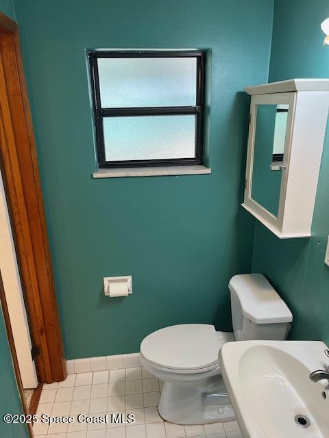 124 E Dover St E, Satellite Beach, FL 32937 - bathroom with toilet, a sink, healthy amount of natural light, and tile patterned flooring