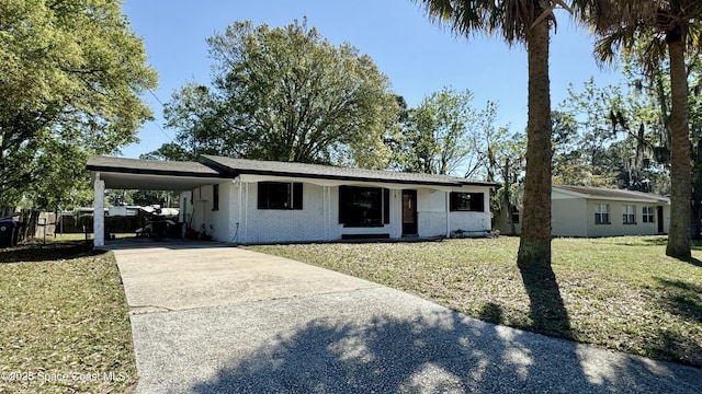 view of front of house with a carport, concrete driveway, brick siding, and a front lawn