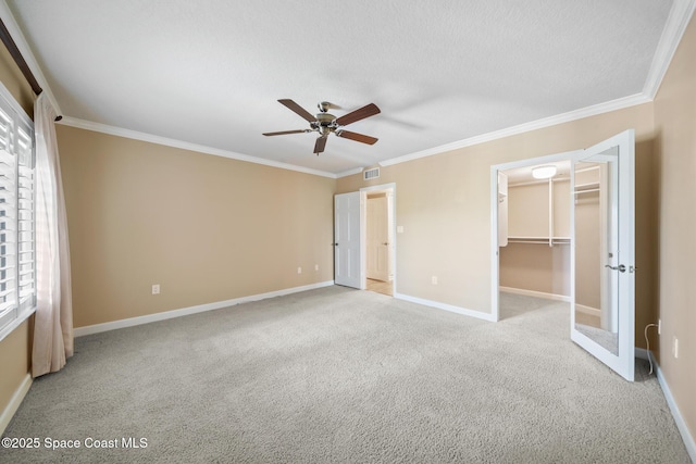 unfurnished bedroom with light carpet, baseboards, visible vents, and crown molding