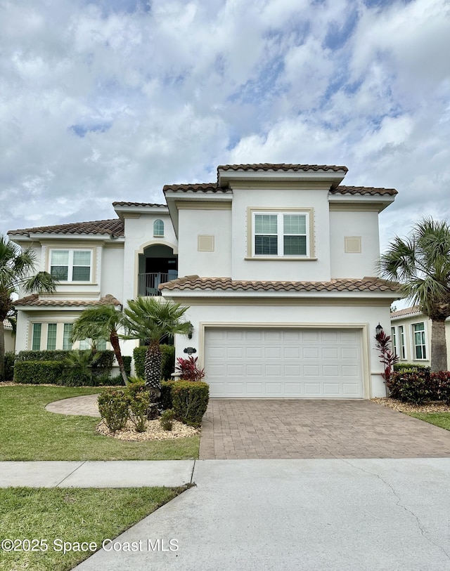 view of front facade with a garage, decorative driveway, and stucco siding