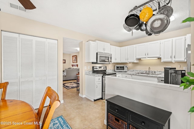 kitchen with white cabinets, stainless steel appliances, and light countertops