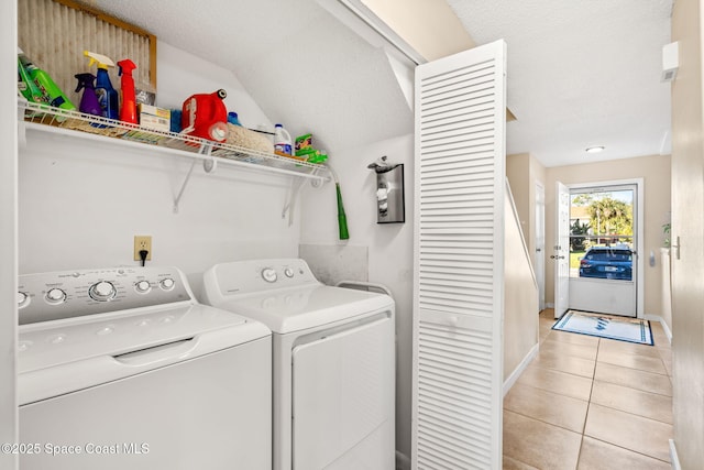 washroom with laundry area, baseboards, washing machine and clothes dryer, and light tile patterned floors