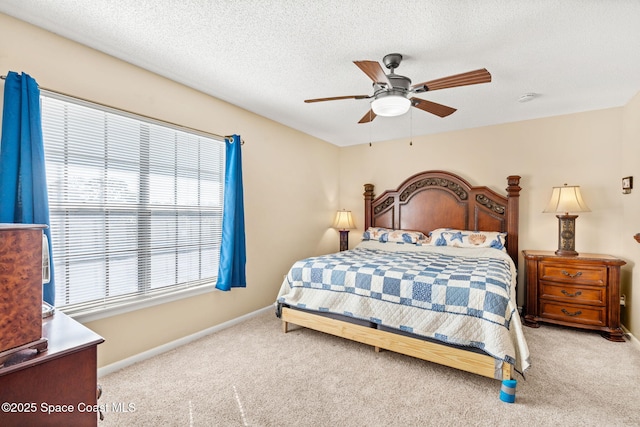 bedroom featuring light carpet, ceiling fan, a textured ceiling, and baseboards