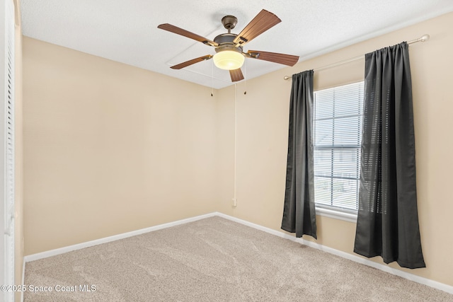 unfurnished room with ceiling fan, baseboards, and light colored carpet