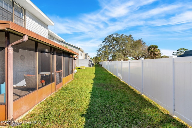 view of yard with a sunroom and a fenced backyard